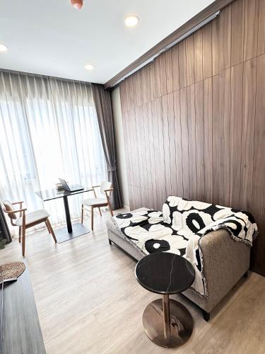 a living room with a bed and a table at Muay Thai Apartment - Ratchada in Bangkok
