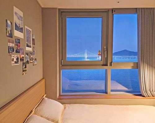 a bedroom with a window with a view of a bridge at 오늘도광안씨 in Busan