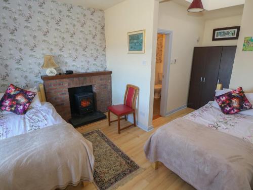 a living room with two beds and a fireplace at Sea View House in Renvyle