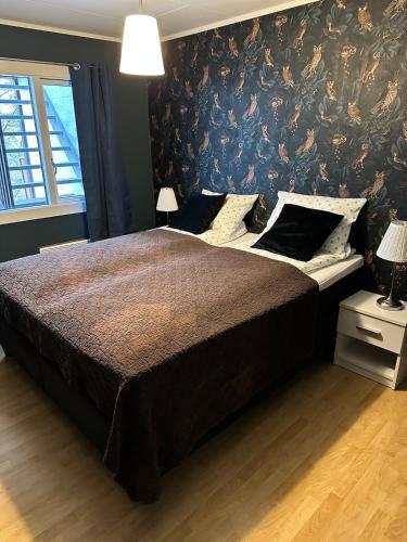 a bedroom with a large bed with a floral wallpaper at Stavern Terrace in Larvik