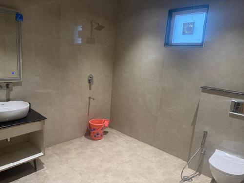 a bathroom with a shower and a toilet and a sink at Agastya Resort in Bāri