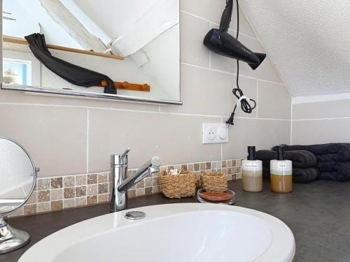 a bathroom with a white sink and a mirror at Le Balcon des Rois in Dourdan