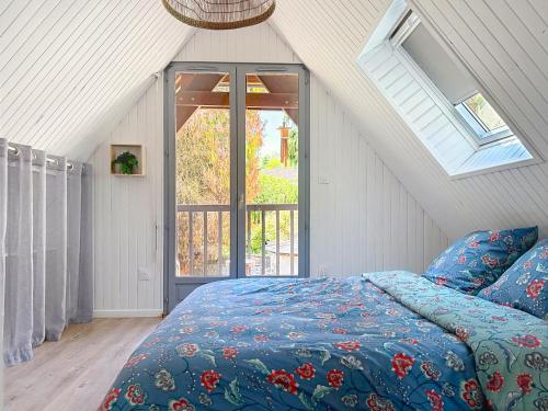 a bedroom with a bed with a blue comforter and a window at Le Balcon des Rois in Dourdan