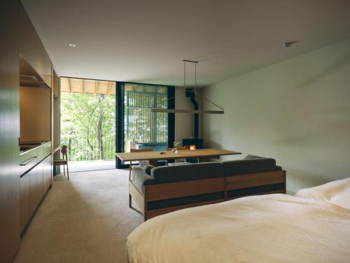 a bedroom with a bed and a table and a couch at SANU 2nd Home Nasu 3rd in Nasu
