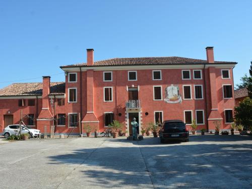 Pontecchio Polesine的住宿－Belvilla by OYO Villa Romana Due，一座大型红砖建筑,前面有一辆汽车