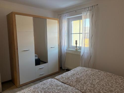 a bedroom with a dresser and a bed and a window at Ferienwohnung Zaglmann in Zandt