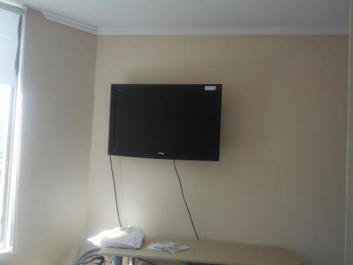 telewizor z płaskim ekranem wiszący na ścianie w obiekcie Coraceros Apartment w mieście Viña del Mar