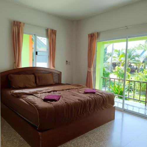 a bedroom with a large bed and a balcony at Banmairimfungnamkohchang in Ban Dan Kao