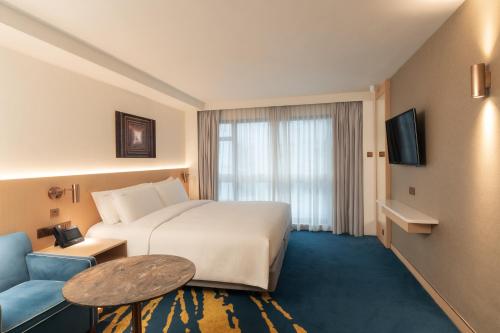 a hotel room with a bed and a table and a couch at Holiday Inn Golden Mile by IHG in Hong Kong