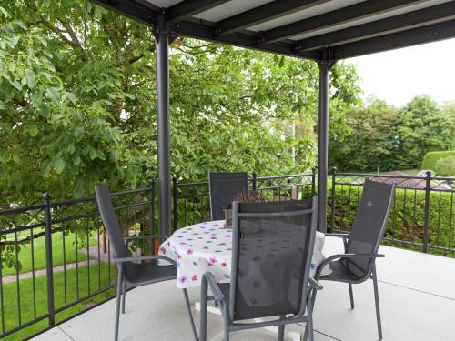a table and chairs on a patio with a fence at Beautiful Apartment in Morscheid Riedenburg in Morbach