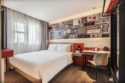 a hotel room with a large bed and a desk at Ibis Beijing Tiananmen Square in Beijing