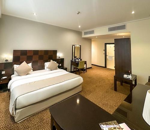 a hotel room with a large bed and a desk at Ayass Hotel in Amman