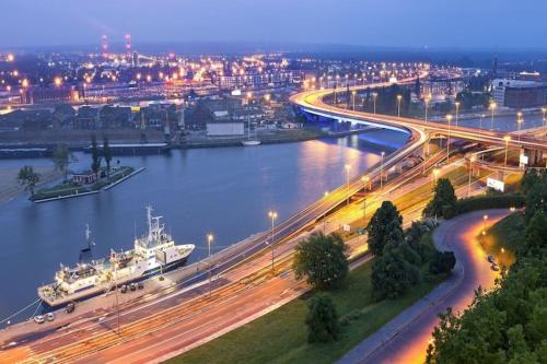 a river with a bridge and a city at night at Holiday House in Szczecin at the lake with parking space for 4 persons in Szczecin
