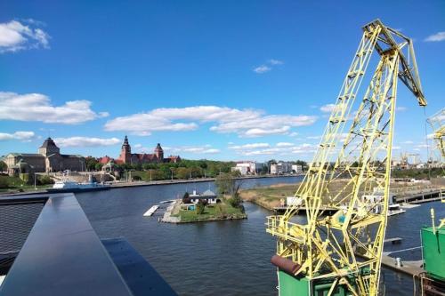 a large yellow crane sitting on top of a river at Holiday House in Szczecin at the lake with parking space for 4 persons in Szczecin