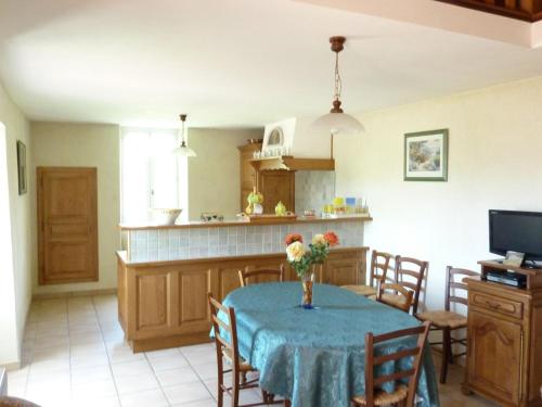 une cuisine avec une table et un vase de fleurs. dans l'établissement Beautiful Holiday Home in Saint Pons, à Berzème