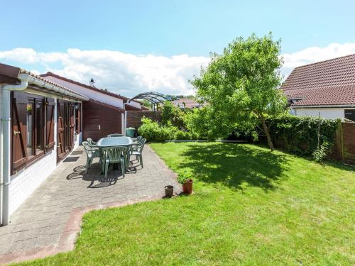 um pátio com uma mesa e cadeiras num quintal em This connected holiday home em Bredene