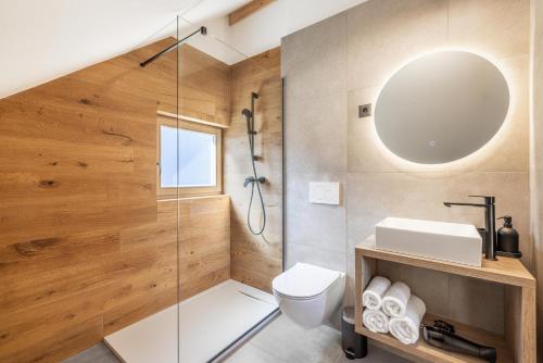 a bathroom with a shower and a toilet and a sink at Chalet Bela in Bohinjska Bela