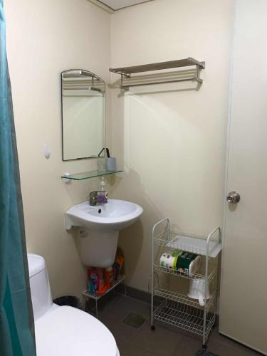 a bathroom with a sink and a toilet and a mirror at Atria Condo in Iloilo City