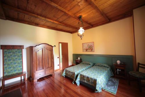 a bedroom with a bed and a wooden ceiling at Hotel Valganna - Tre Risotti in Valganna