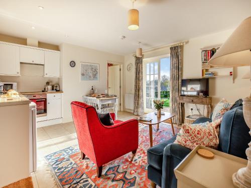 a living room with a red chair and a couch at Fig Cottage - Ukc6129 in Eastdean