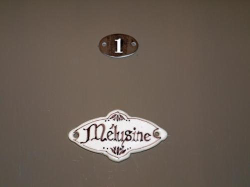 a sign on a wall with a clock on it at Le Chapeau Rouge in Lusignan