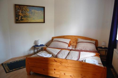 ein Schlafzimmer mit einem Holzbett mit vier Kissen in der Unterkunft Ferienwohnung Zinn in Rockeskyll