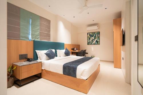 a bedroom with a large bed and a desk at Airotel in Pune