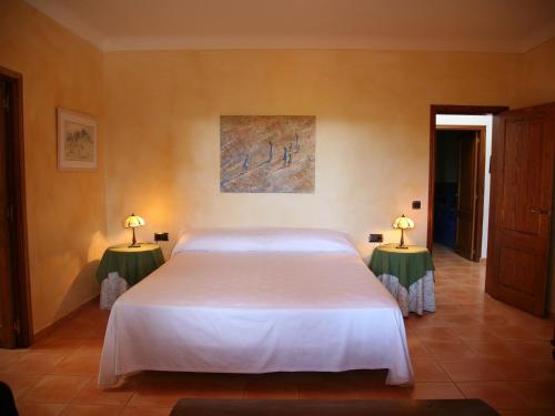 a bedroom with a large white bed with two tables at Holiday Home in St Josep de sa Talaia with Pool in Sant Josep de sa Talaia