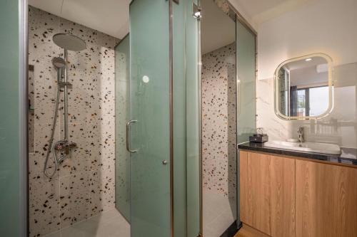 a bathroom with a shower with a glass door at Mai Living Apartment in Danang