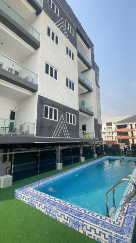 a building with a swimming pool in front of a building at Dephantom Continental Hotel in Lagos