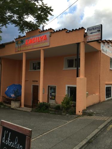 un edificio naranja con un letrero delante de él en L'Acilya, en Roussillon en Isère