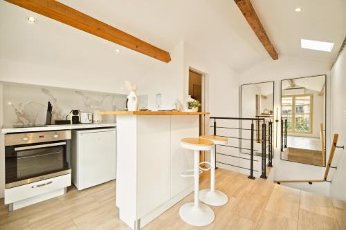 a kitchen with white cabinets and a counter top at Saint Tropez High standing 3 in Saint-Tropez
