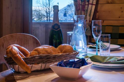 a table with a basket of bread and a bottle of wine at Aparthotel Gallahaus in Zell am Ziller