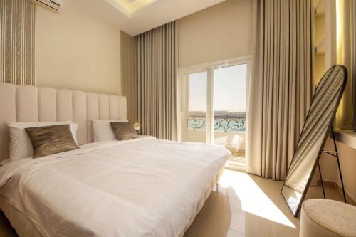 a bedroom with a large bed and a large window at Silk Valley – Beachfront 3BR near Al Hamriyah in Sharjah