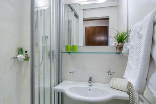a white bathroom with a sink and a shower at Aparthotel Gallahaus in Zell am Ziller