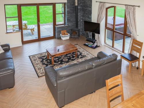 a living room with a leather couch and a table at Laurel Cottage - Ukc6256 in Linlithgow