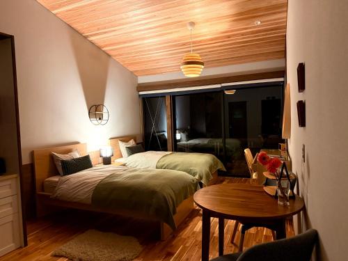 a bedroom with a bed and a table in it at blue in green 飯田高原 cottage and cafe in Iida