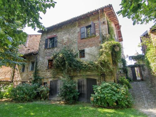 un viejo edificio de piedra con hiedra. en Belvilla by OYO Castagnola en Rocca Grimalda