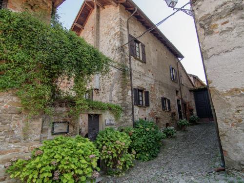 un antiguo edificio de piedra con plantas en una calle en Belvilla by OYO Castagnola en Rocca Grimalda