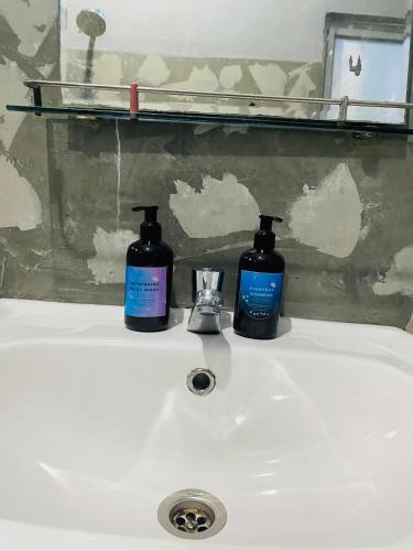 two bottles ofodorizers sitting on top of a bathroom sink at Ocean Breeze in Dickwella