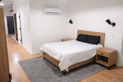 a bedroom with a large bed with white sheets at Pratt St Brand New Studio Loft Elevator Building in Hartford
