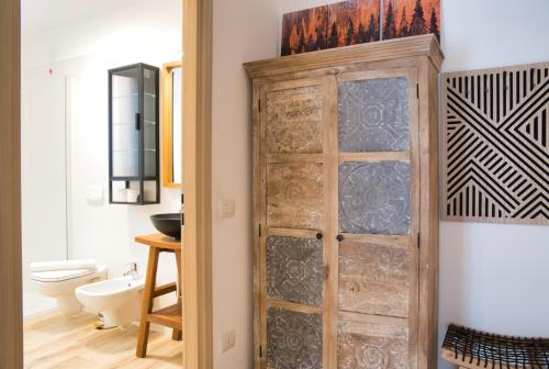 a bathroom with a wooden door next to a toilet at NNHouse: large terrace and marvelous view in Cassina Valsassina