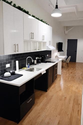 a kitchen with white cabinets and a sink at Pratt St Brand New Studio Loft Elevator Building in Hartford