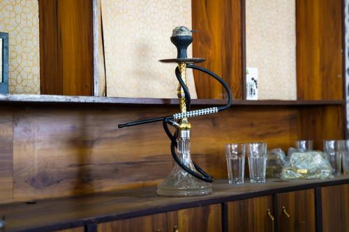 a metal stand on a shelf with glasses on it at AARYA Corbett Resort & SPA - 8 minutes drive to Kosi River in Nainital