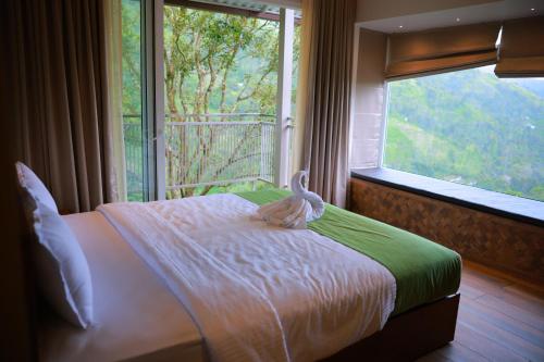 a bedroom with a bed with a stuffed animal on it at La Paraiso by WhiteTrip in Vagamon
