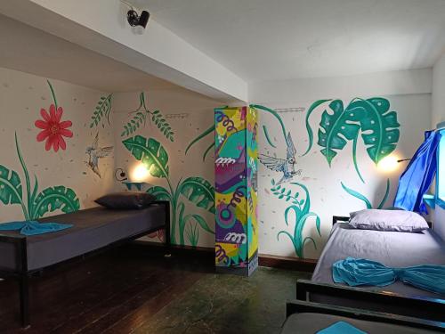 a room with a bed and a mural on the wall at Gili Beach Bum Hostel in Gili Trawangan