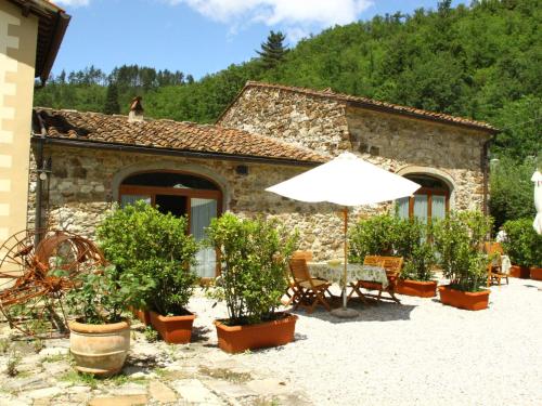 een huis met een tafel en een paraplu ervoor bij Belvilla by OYO Le Olive in Vaglia