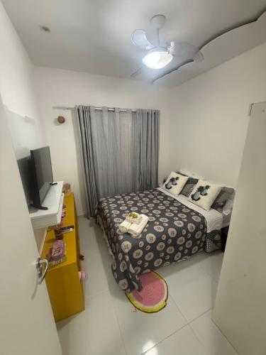 a small bedroom with a bed and a tv at Casa 2 quarto em condomínio in Camaçari