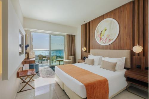 a hotel room with a bed and a balcony at NissiBlu Beach Resort in Ayia Napa