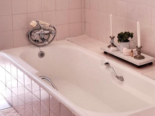 a white bath tub with two candles and a fan at Schalkenbosch Farm Cottages in Tulbagh